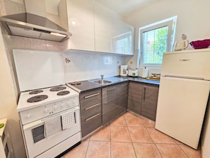A kitchen with a stove, oven, sink, and a refrigerator. - Wohnung für 4 Personen, 100m vom Strand entfernt by Interhome (Crikvenica)