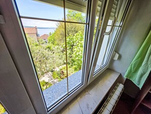 A room with a large window, a radiator, and a green curtain. - Wohnung für 4 Personen, 100m vom Strand entfernt by Interhome (Crikvenica)