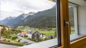 A window view of a residential area with houses, a road, and mountains in the background. - Chasa Vista Lischana by Interhome (Scuol)