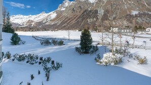 A snow-covered landscape with mountains in the background, a clear sky, and a few trees in the foreground. - Residenz Alpenrose34 by Interhome (Sils Maria)