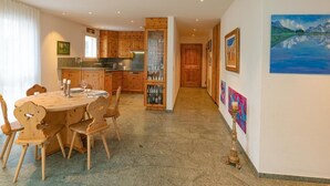 A spacious kitchen with wooden cabinets and a dining area with a table and chairs. - Residenz Alpenrose34 by Interhome (Sils Maria)