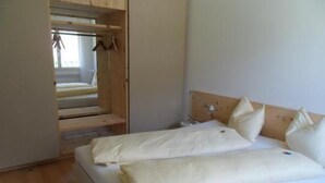 Ein Schlafzimmer mit einem Bett, einem Holz-Kopfteil und einem Holzschrank.
