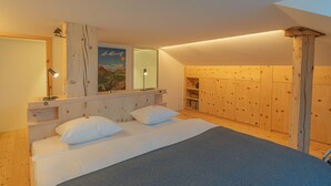 Ein Schlafzimmer mit einem großen Bett, einem Holzkopfstück, einem Spiegel und einem Poster an der Wand.