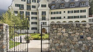 A large, multi-story building with a stone facade and a gated entrance. - Residenz Alpenrose15 by Interhome (Sils Maria)
