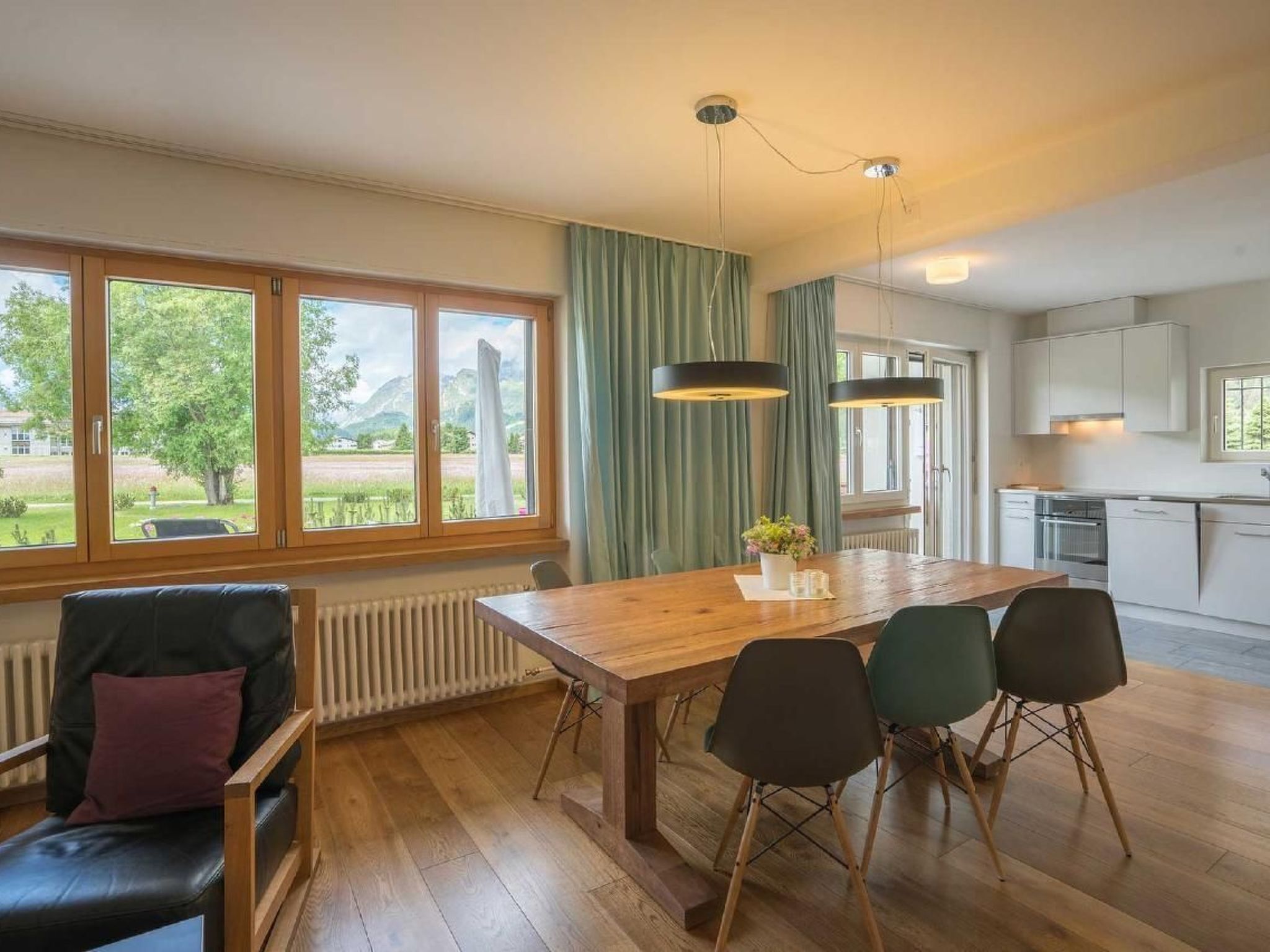 Eine moderne Küche mit weißen Schränken und einem großen Fenster.