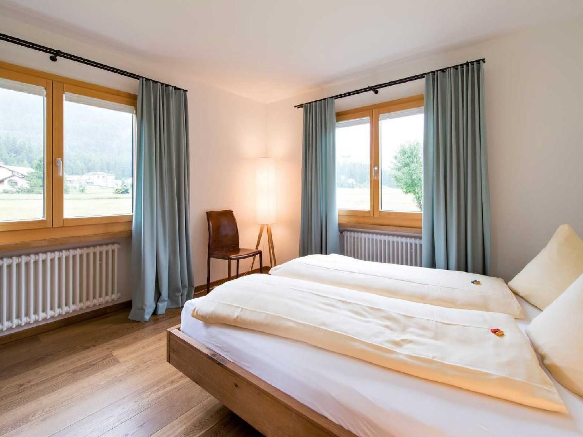 Ein Schlafzimmer mit einem Bett, einem Sessel und einer Lampe.