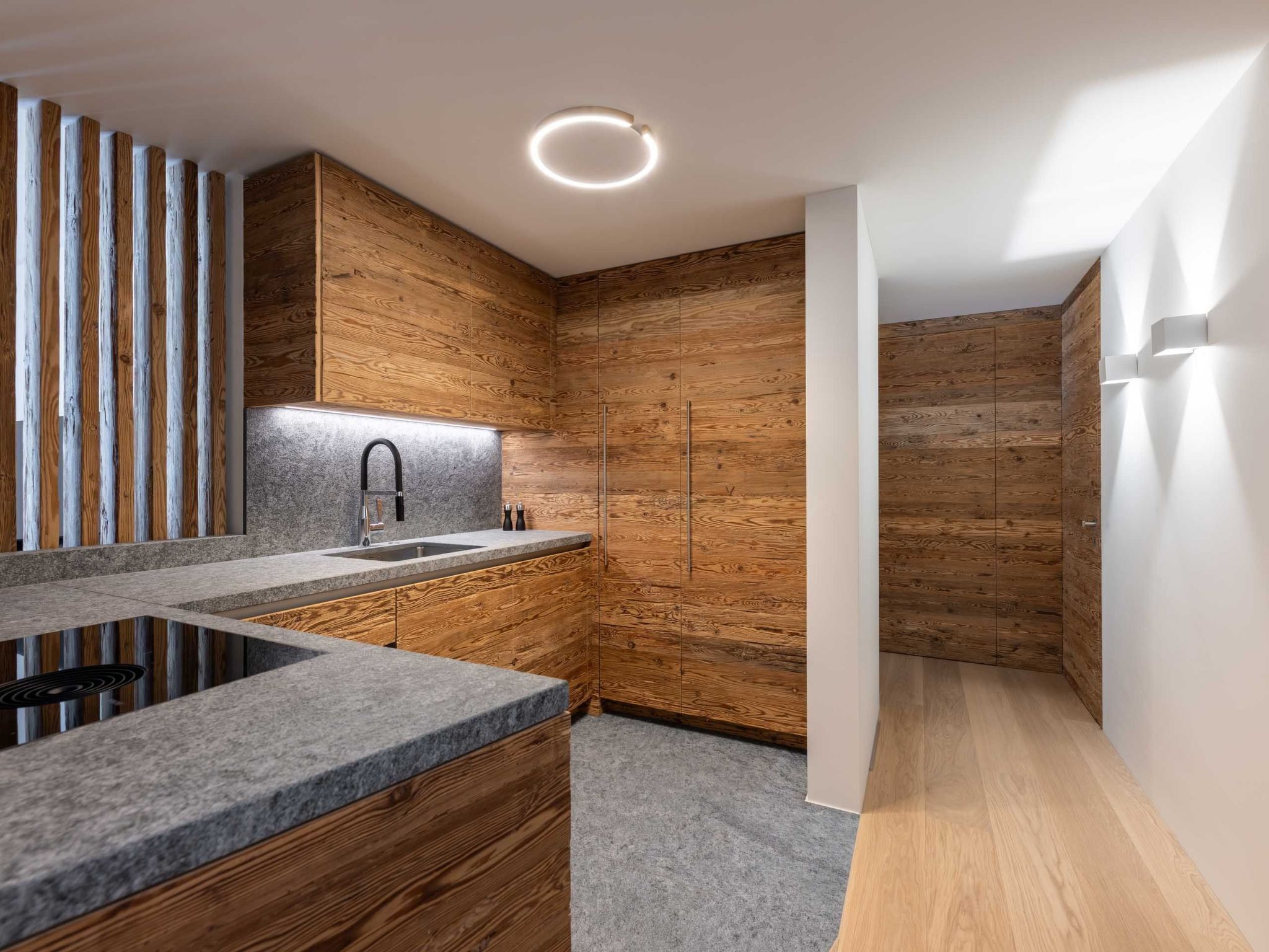 Eine moderne Küche mit Holzschränken, einer Granit-Arbeitsplatte und einer eingebauten Spüle.