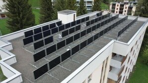 Un immeuble à plusieurs étages doté d’un toit plat et de plusieurs installations de panneaux solaires.
