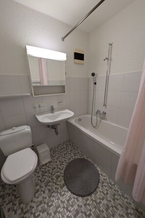 Une salle de bain avec des toilettes, un lavabo et une baignoire.