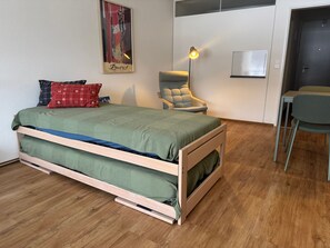 Une chambre moderne avec un lit superposé, un bureau, une chaise et une lampe.