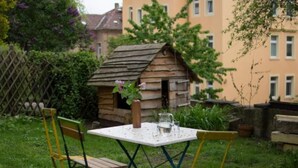 A small wooden structure resembling a shed in a garden with a table and chairs. - Apfeltraum by Interhome (Dresden)