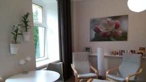 A modern room with a round table, two chairs, a bookshelf, and a window with curtains. - Apfeltraum by Interhome (Dresden)