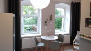 A modern kitchen with a dining area, large windows, and a hanging light fixture. - Apfeltraum by Interhome (Dresden)