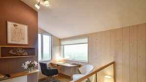 Un appartamento moderno con arredamento in legno, una scrivania, una sedia e una scala.