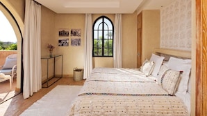 Une chambre avec un grand lit, une fenêtre et une vue sur la verdure.