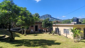 A house with a garden, a small patio, and a mountain in the background. - Perfect 1-bedroom house in enchanting Tepoztlán for your getaway (Tepoztlán)