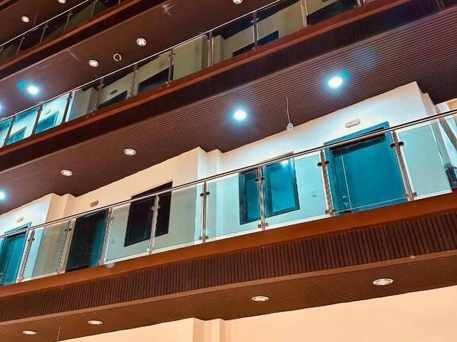 A multi-story hotel with a modern design, featuring balconies on each floor, large windows, and a prominent entrance.