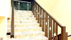 Una escalera con escalones de mármol y barandillas de madera.