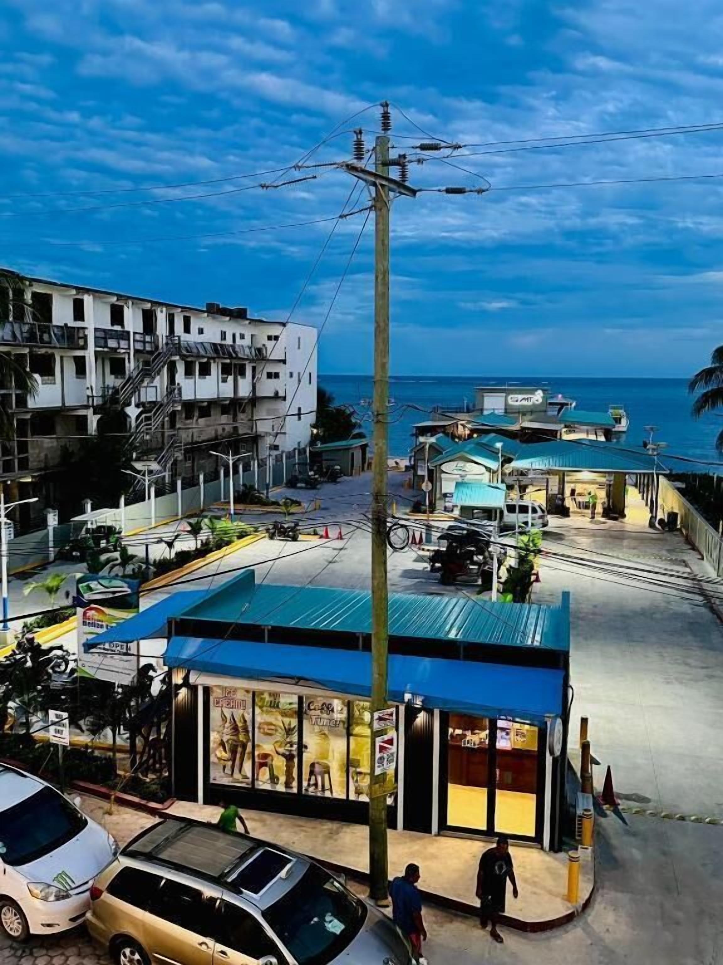 A coastal town with a prominent building featuring a blue roof and a shop with glass display windows.