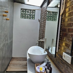Une salle de bain moderne avec un grand lavabo blanc, une douche et un miroir.