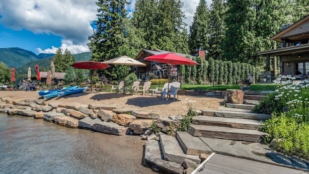 A lakeside deck with outdoor seating, a dock, and a mountain backdrop. - Luxury Hope Waterfront Home and Guest House (Hope)