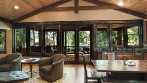 A spacious interior with a high ceiling, large windows, and a rustic wooden dining area. - Luxury Hope Waterfront Home and Guest House (Hope)