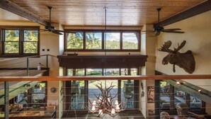 A spacious interior with a high ceiling, large windows, and a mounted moose head. - Luxury Hope Waterfront Home and Guest House (Hope)