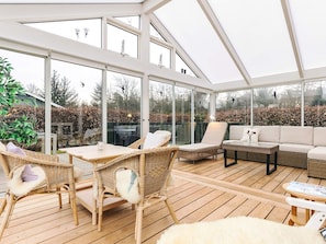 A covered outdoor area with wicker furniture, a table, and a sofa. - 4 Star Holiday Home in Hals (Hals)