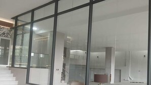 Un interior espacioso y moderno con amplios ventanales, piso pulido y mobiliario contemporáneo.