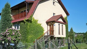 A two-story house with a red roof, a balcony, and a small porch. - Holiday Flat in Stepnica for 7 Persons (Stepnica)
