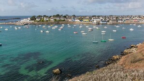 A coastal town with numerous boats in the water, a rocky shoreline, and houses in the background. - An Ty Porzh by Interhome (Portsall/Porsguen)