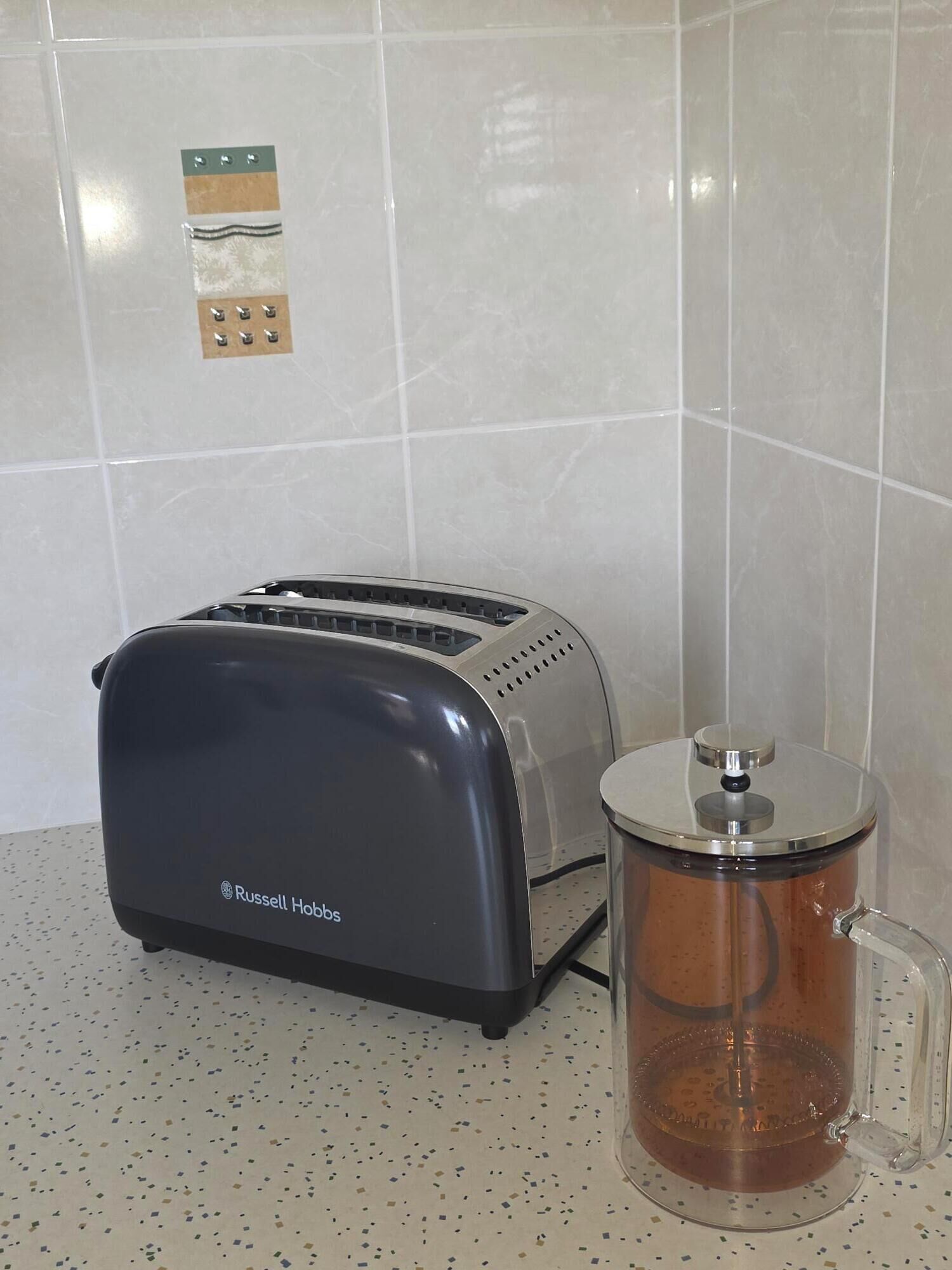 Eine Küche mit einem Toaster und einer Kaffeemaschine auf der Arbeitsfläche.
