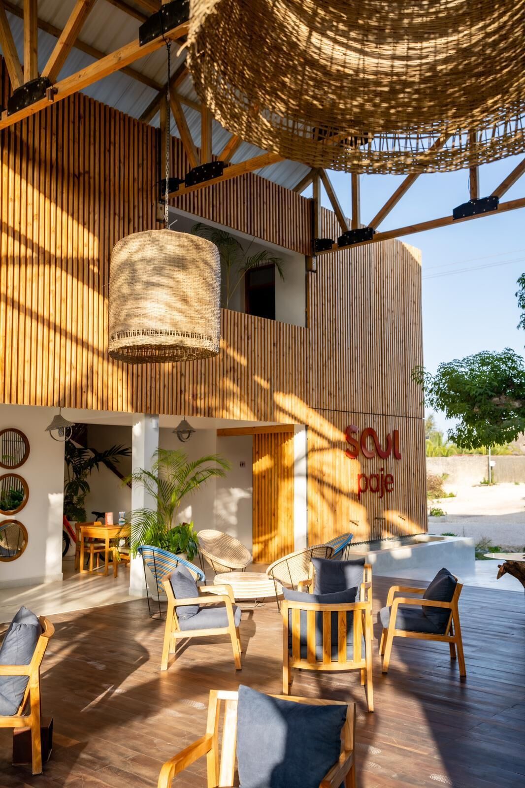 Zona relax esterna moderna con mobili in legno e soffitto intrecciato.