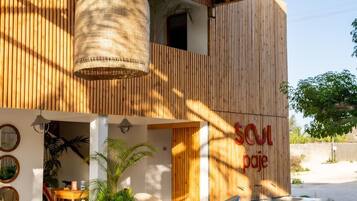 Zona relax esterna moderna con mobili in legno e soffitto intrecciato.