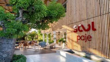An outdoor seating area with wicker furniture and a large tree.