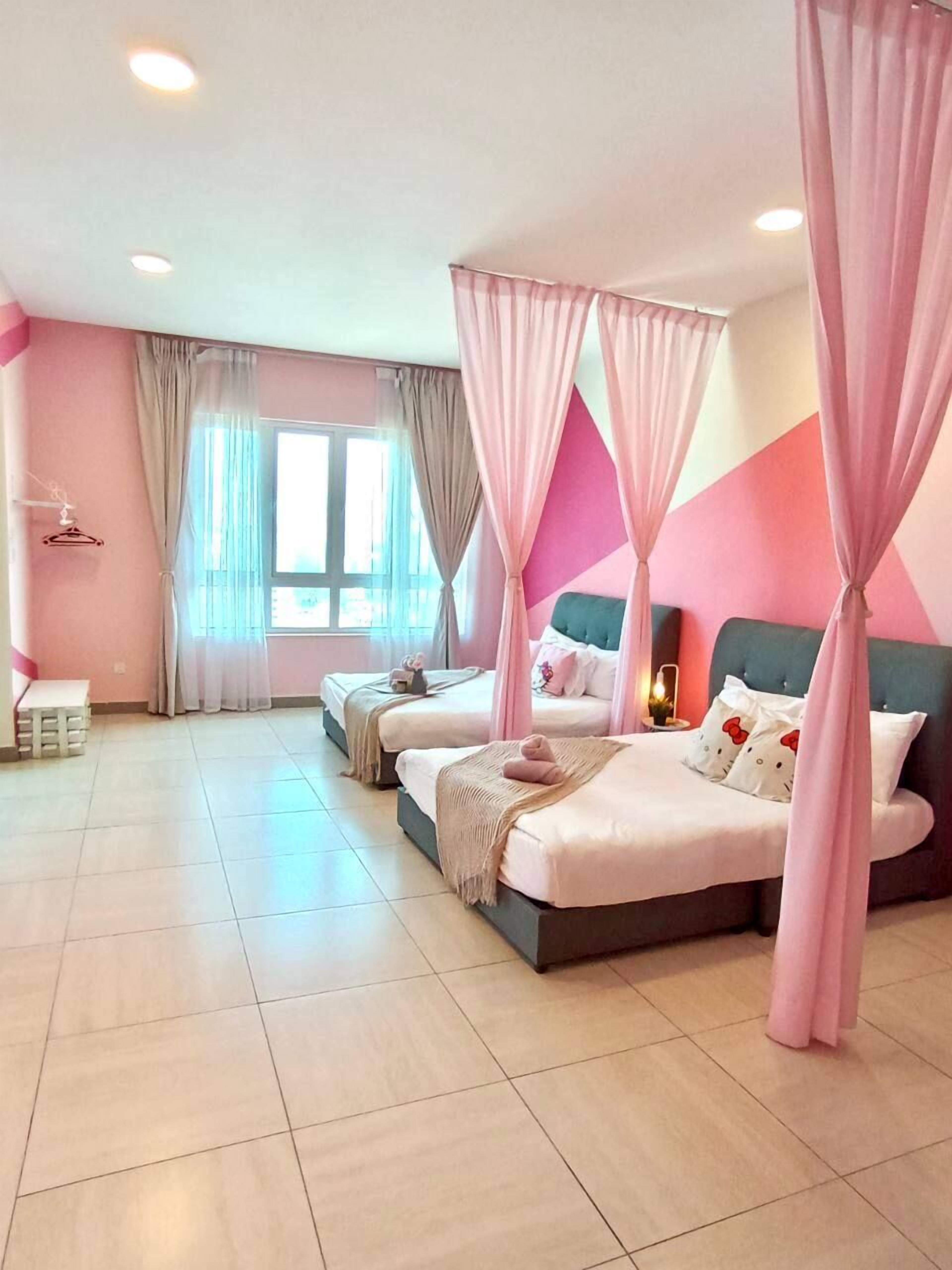 A bedroom with two beds, a large window, and pink curtains.