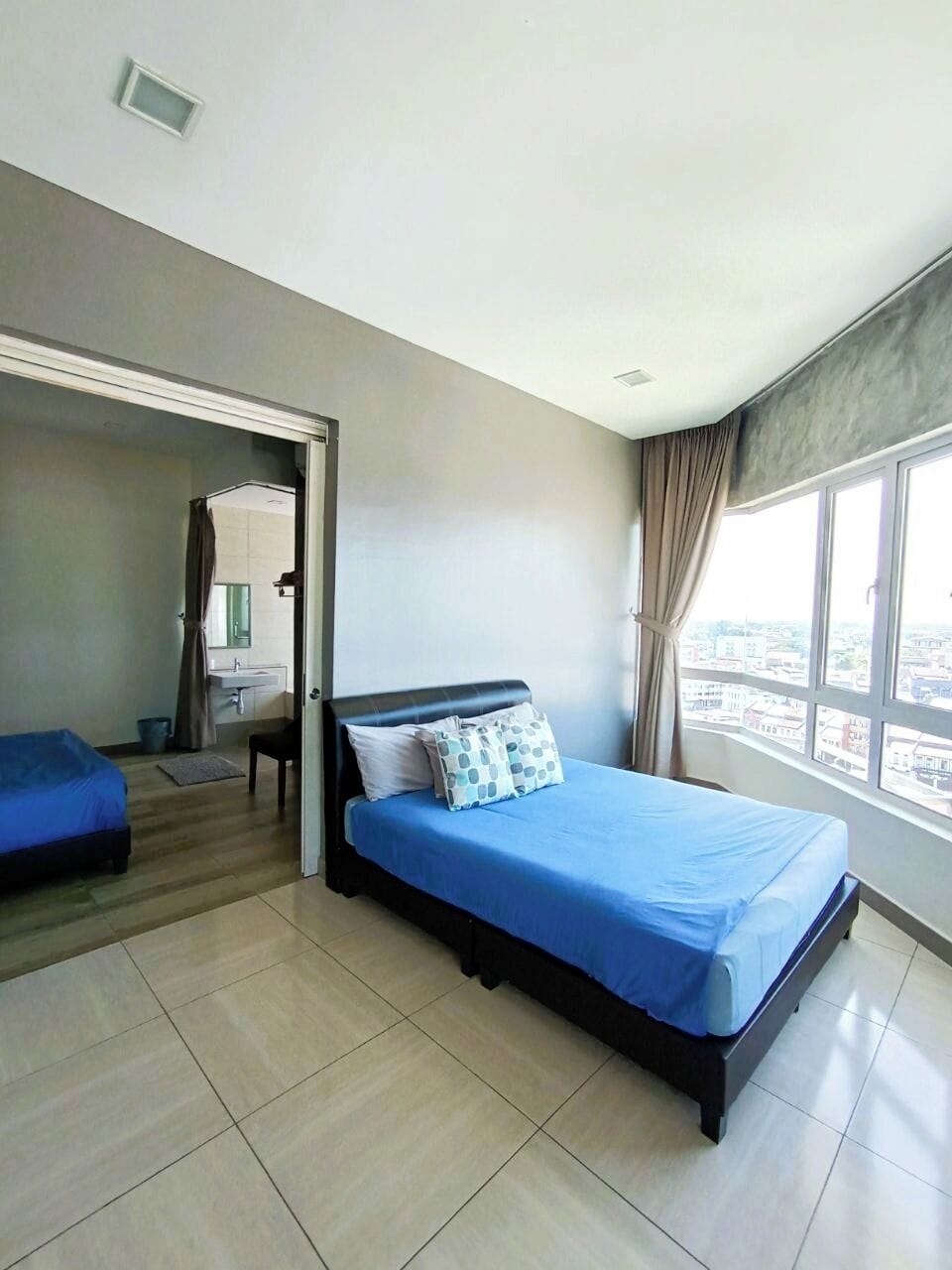 Une chambre avec un lit, un bureau et une vue sur la ville.