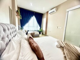 Une chambre d’hôtel avec un grand lit, une table de chevet, une fenêtre avec des rideaux, un appareil de climatisation et une armoire.