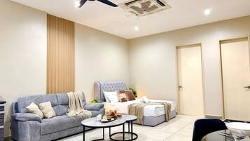 A modern living room with a sofa, a coffee table, a bed, and a dining area.