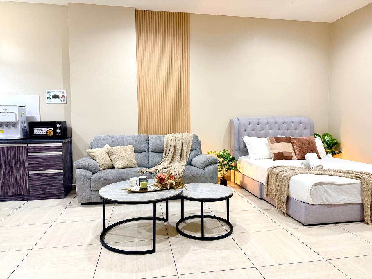 A modern living room with a sofa, a bed, and a coffee table.