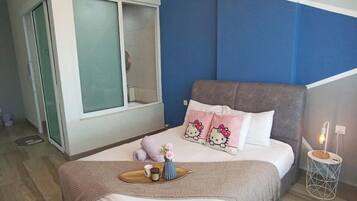 Un dormitorio moderno con cama, mesita de noche con lámpara, ventana y puerta.