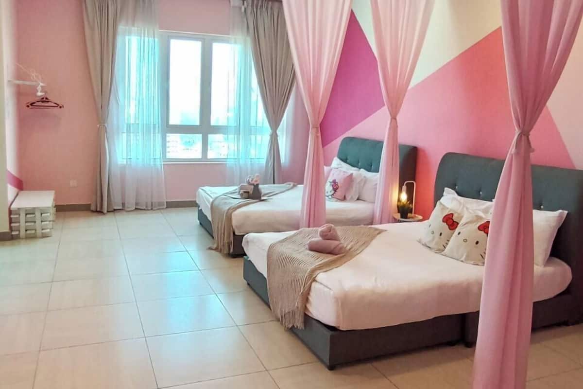 A bedroom with two beds, a vanity, and a window with curtains.