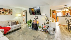 A living room with a sofa, starfish rug, and a TV. There is a kitchen in the background. - Pet Friendly, Private! Multi-Level Brookline Home (Pittsburgh)