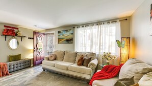 A cozy living room with a beige sofa, a round mirror, and a starfish-patterned rug. - Pet Friendly, Private! Multi-Level Brookline Home (Pittsburgh)