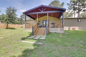 A covered outdoor area with a staircase leading to a door, surrounded by a grassy yard and a wooden fence. - Hike & Fish! Tyler Family Home 11 Mi to State Park (Tyler)