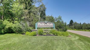 A sign with the text 'Peek's Peak Welcomes You' surrounded by greenery and a road. - Walk to Golf Course! Clymer Summer Escape w/ Deck (Clymer)