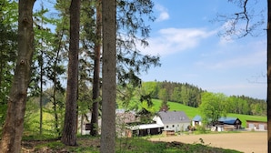 Paisaje rural con una casa, graneros y un campo verde.