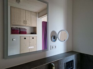 Ein Badezimmer mit einem Holzwaschtisch, einem Spiegel und einem Handtuchhalter.