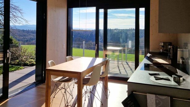 A modern kitchen with a large window overlooking a scenic view. - Tinyhaus Adam by Interhome (Freiamt)