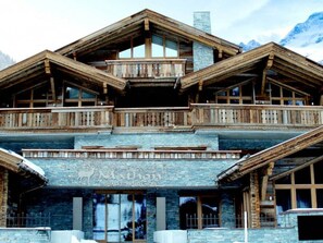 A chalet with a stone facade, wooden balconies, and large windows. - ON Chalet by Interhome (Mathon)